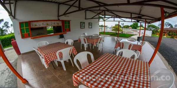 Comedor social cubierto con mesas para grupos en Finca Armenia Rosario