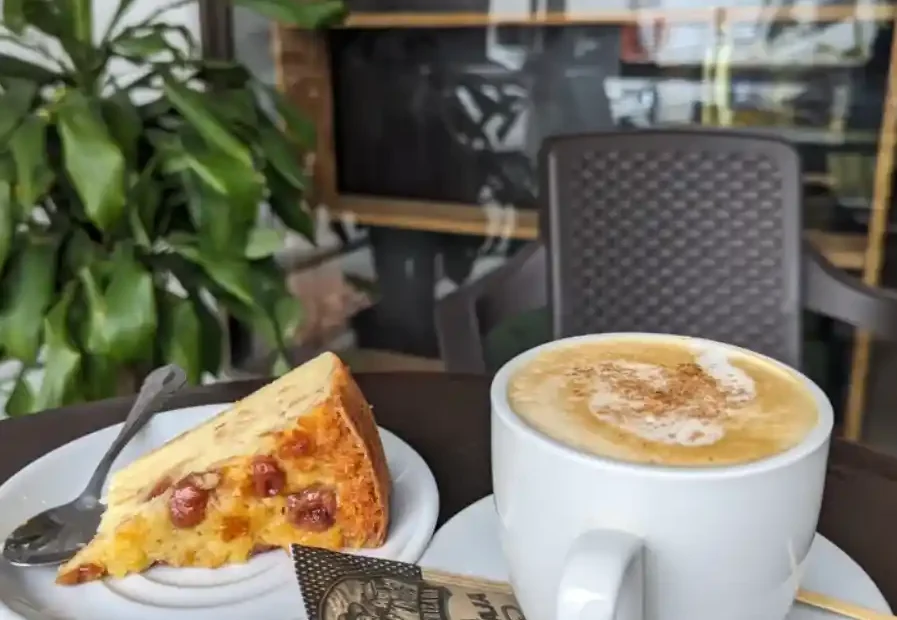 Taza de café con leche y porción de pastel servidas en La Molienda Quindiana de Armenia
