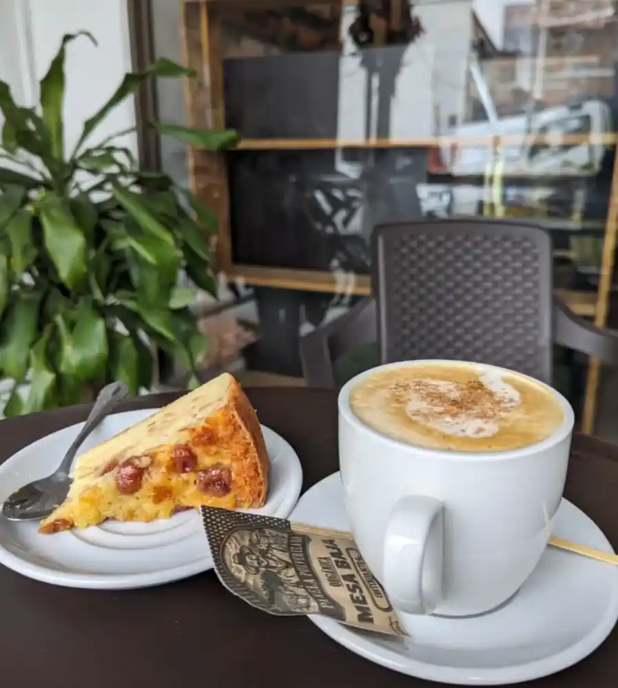 Taza de café con leche y porción de pastel servidas en La Molienda Quindiana de Armenia