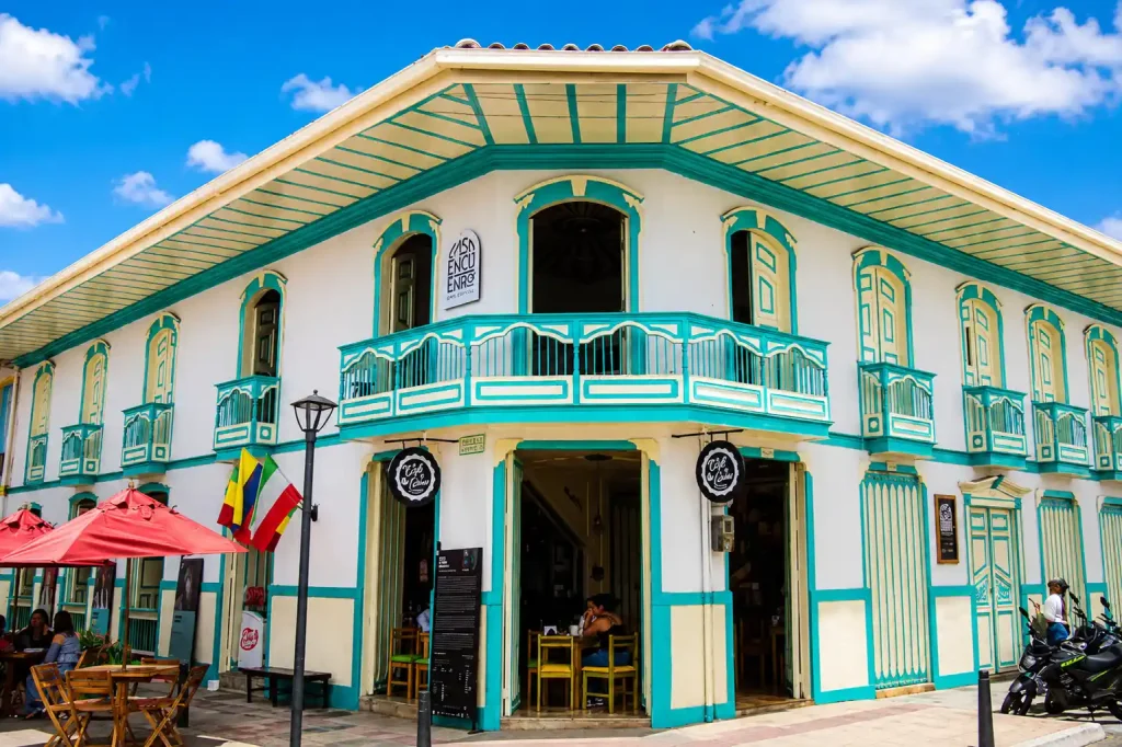 Fachada tradicional blanca y verde de la casa donde funciona El Café de Carlos en Calarcá