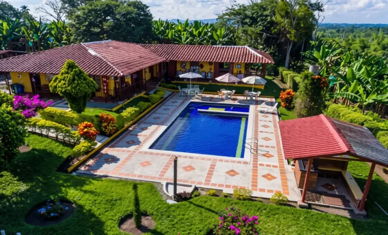 Vista aérea de una finca con piscina, jardines y casa campestre en Armenia