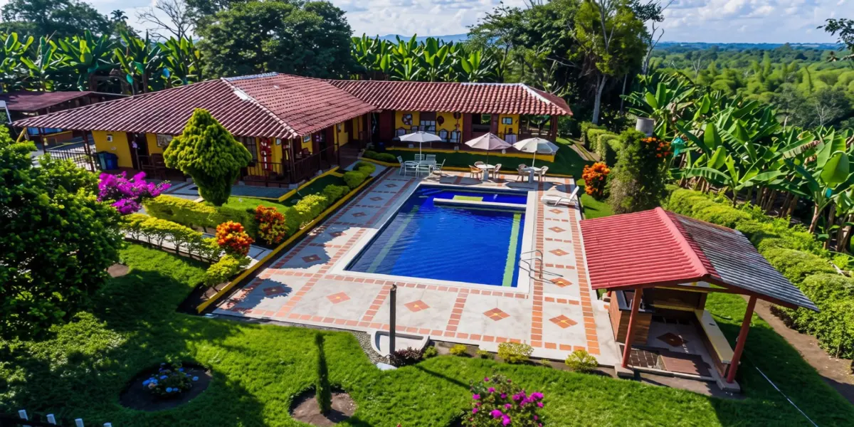 Vista aérea de una finca con piscina, jardines y casa campestre en Armenia