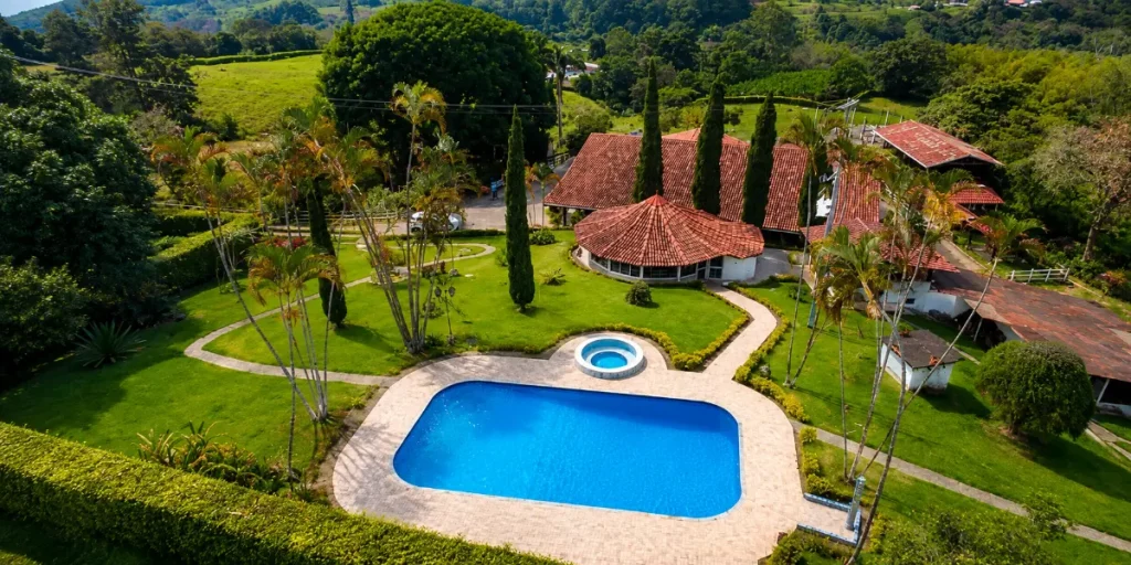 Vista aérea de una finca con piscina, jardines y arquitectura campestre