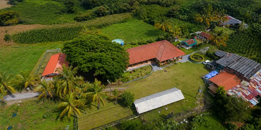 Vista aérea de una finca tradicional rodeada de cultivos y montañas