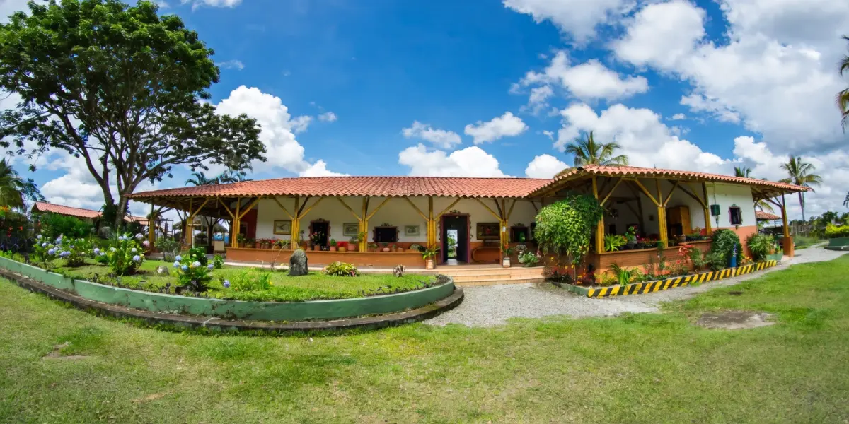 Fachada de finca tradicional con corredor y jardín cuidado
