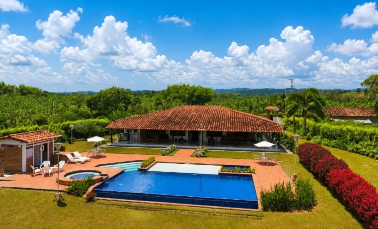 Vista aérea de una finca con piscina y jardines en Quimbaya