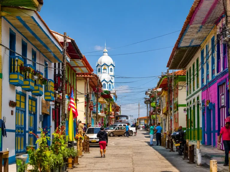 Calle con casas y balcones coloridos y la torre de la iglesia al fondo en Filandia, Quindío