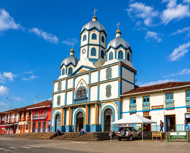 Fachada de la Iglesia Inmaculada Concepción junto a casas coloridas de Filandia, Quindío