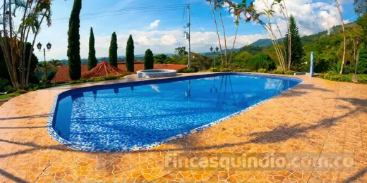 Piscina y zonas verdes de Finca Calarcá Ceiba para descanso en el Quindío, con zona de descanso