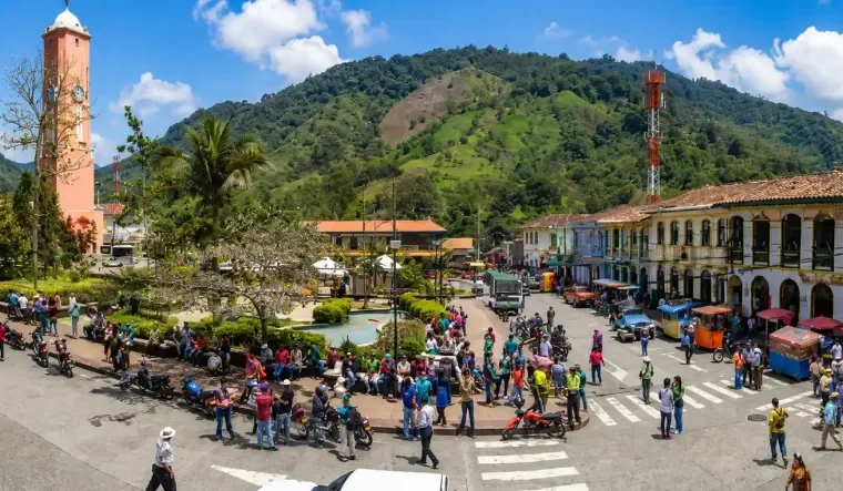 Plaza principal de Pijao con torre central, visitantes, fachadas tradicionales y montanas