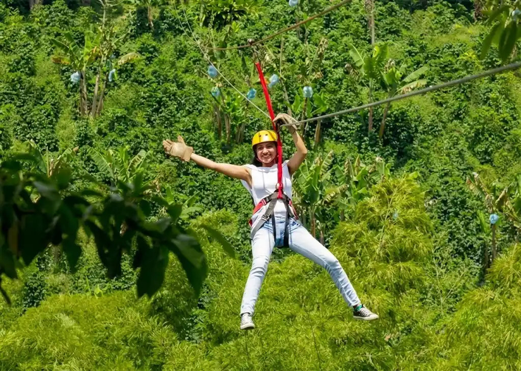 Visitante en una tirolina rodeada de vegetación en PANACA, Quimbaya