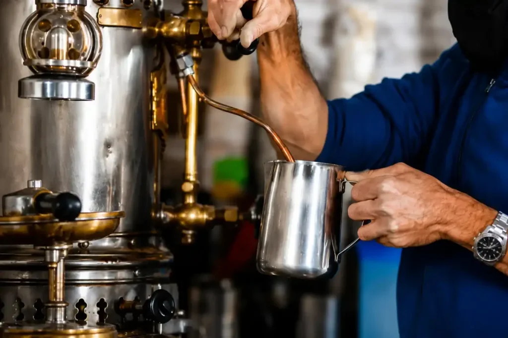 Barista espumando leche junto a una maquina de cafe en Salento, Quindio