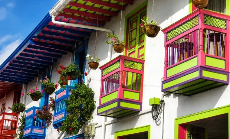 Balcones rosados y verdes con flores en una fachada de la Calle Real de Salento