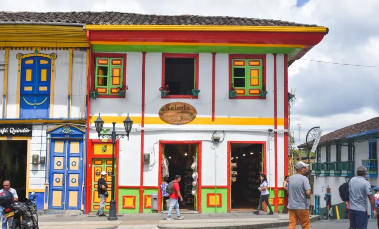 Fachada tradicional blanca con balcones y carpinteria de colores en la Calle Real de Salento