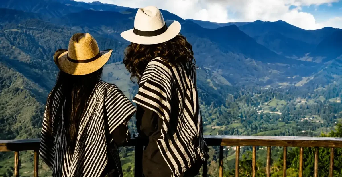Dos visitantes con sombreros observando las montanas desde un mirador de Salento
