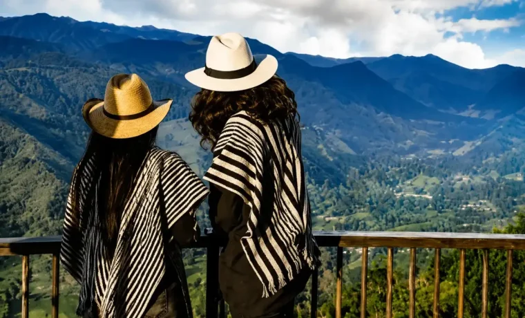 Dos visitantes con sombreros observando las montanas desde un mirador de Salento