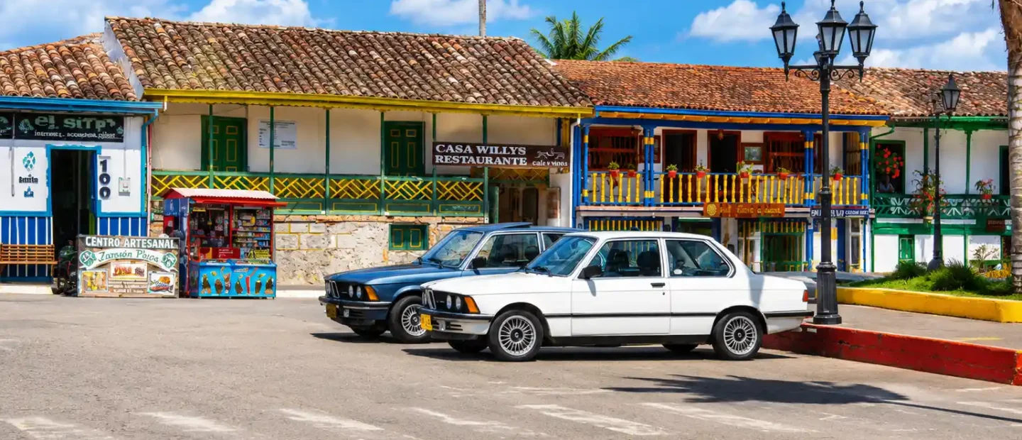 Jeeps Willys estacionados frente a casas tradicionales en la plaza principal de Salento