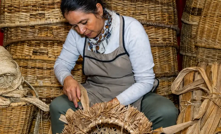 Artesana elaborando una pieza de cestería entre canastos de fibras naturales